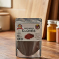 Package of ground cloves with a label on a reflective surface
